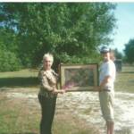 2009 Grand prize winner Barbara Nowling receives her “ Florida Treasures” painting from Alexis of the Florida Panther Project.